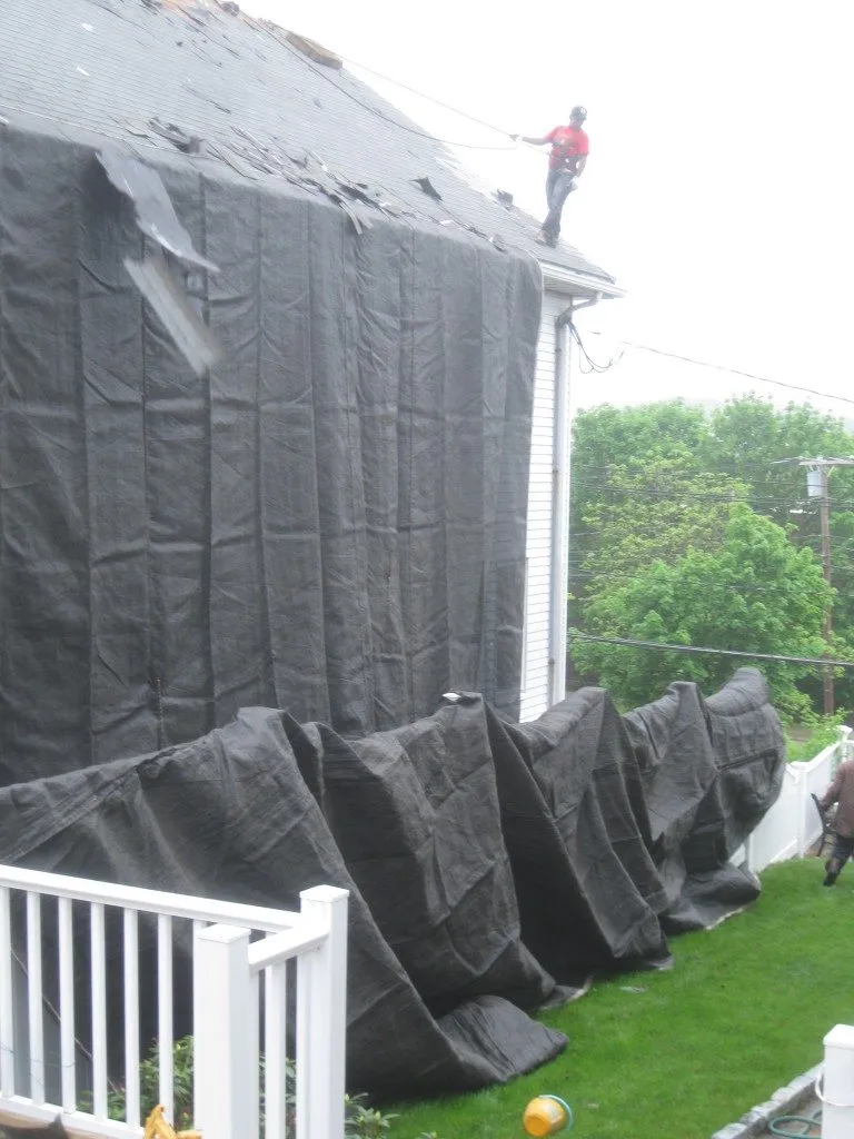 Roofing contractor working in tight quarters to complete detailed roof installation.