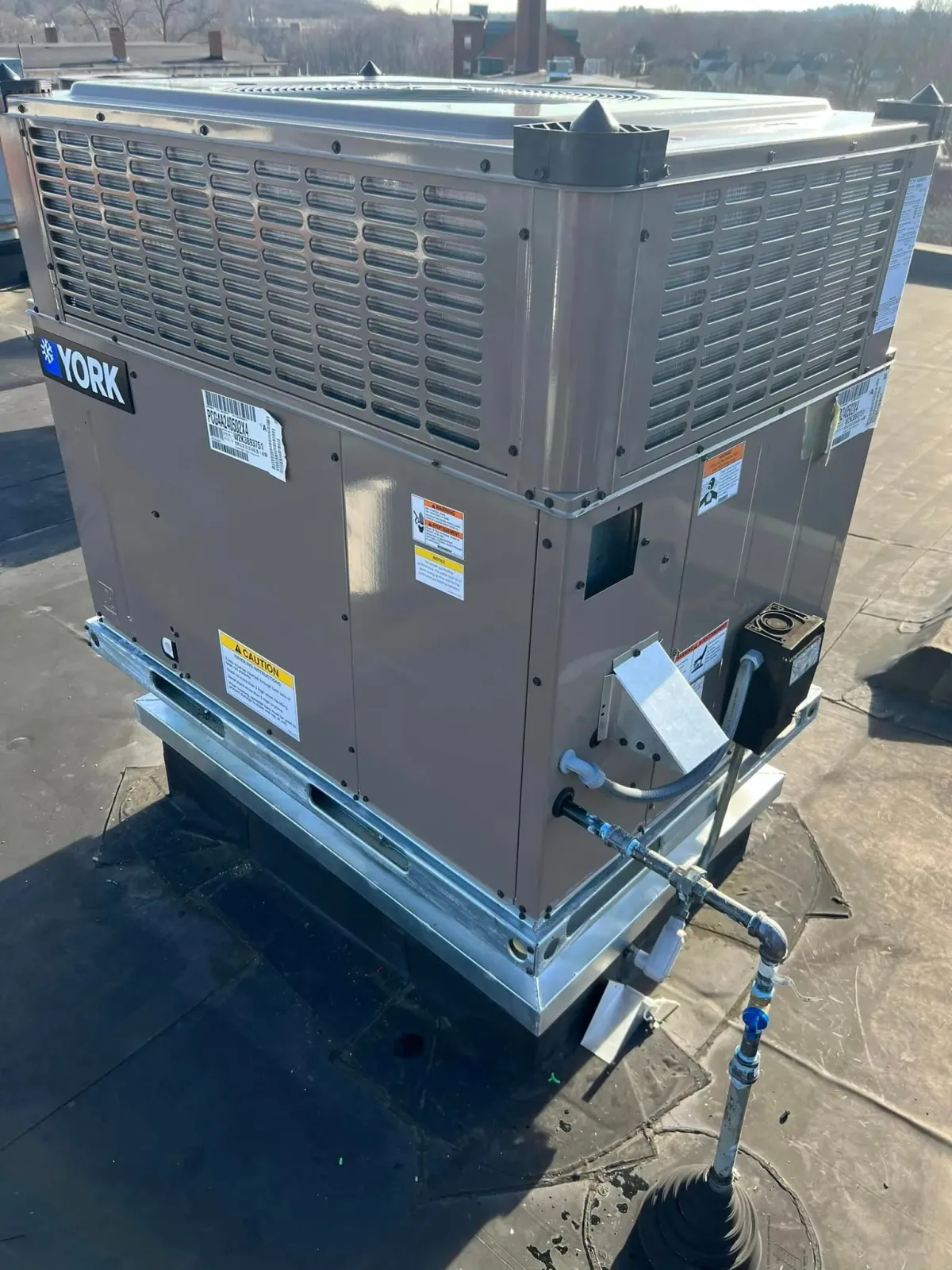 A large air conditioner is sitting on top of a roof.