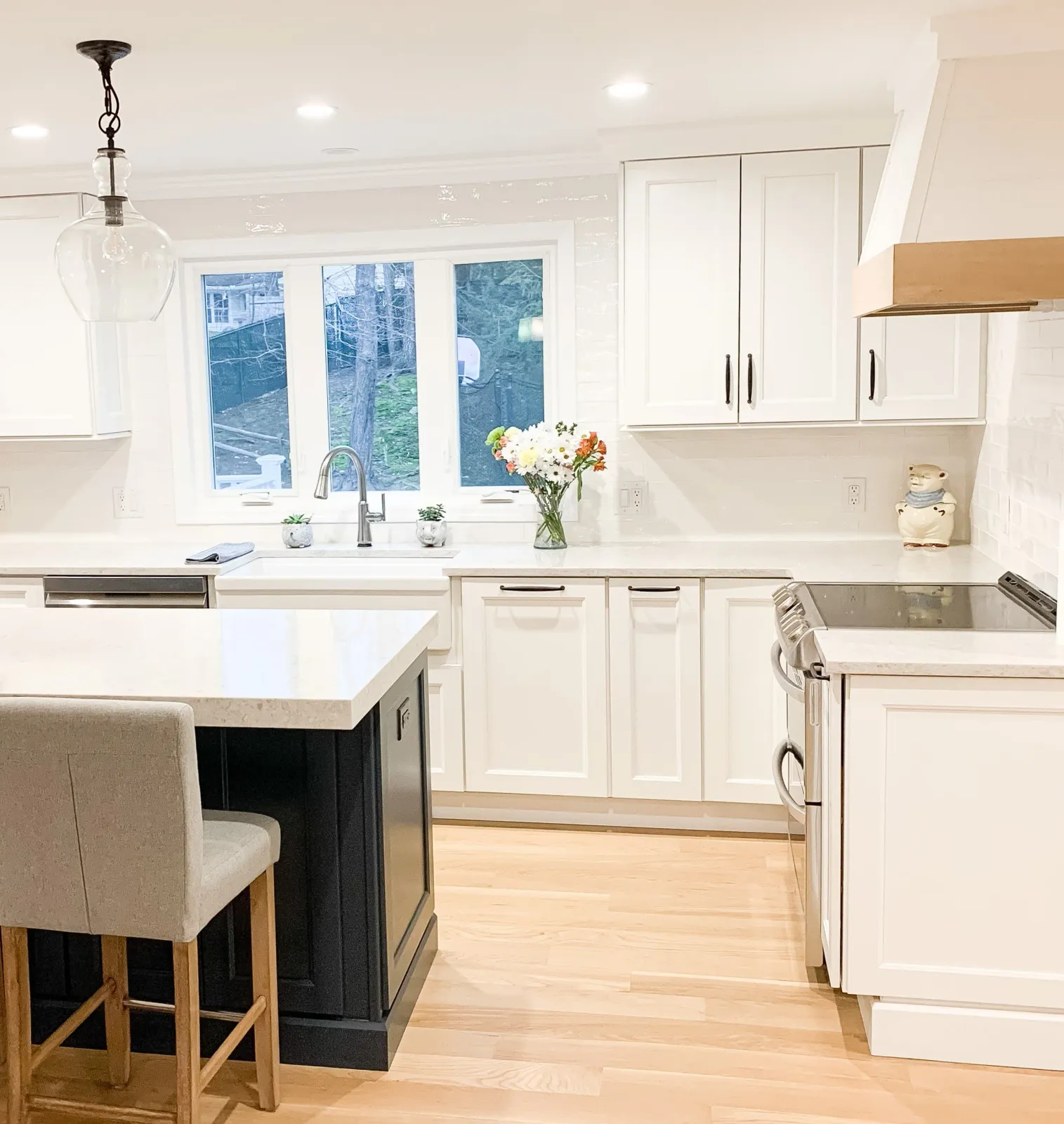 Transitional Kitchen Remodel in Holden, Massachusetts featuring white cabinetry and navy island cabinetry