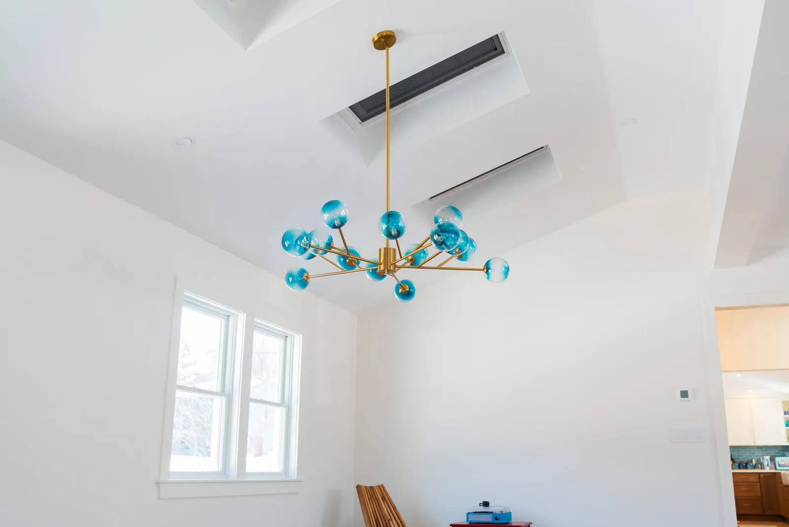 Vaulted ceiling with recessed ductless heads and a statement chandelier