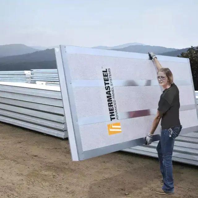 A single worker carrying a full ThermaSteel wall panel