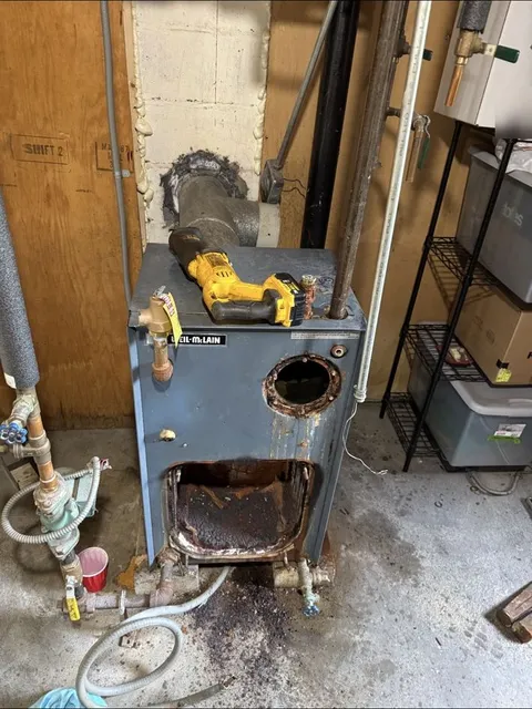 Old rusted boiler being cut apart for removal
