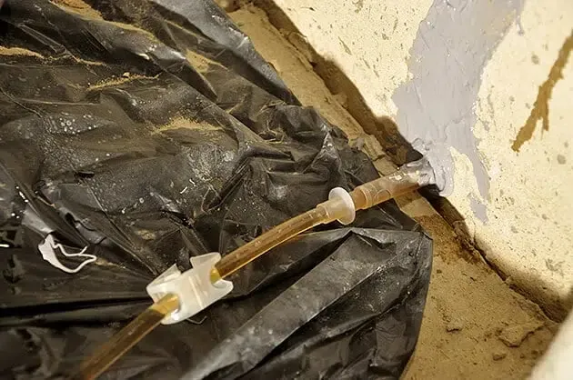 polyurethane being injected into a foundation crack in a wet basement