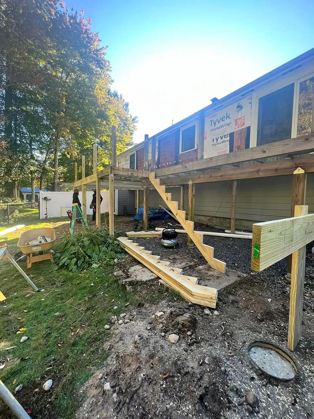 A wooden deck is being built on the side of a house
