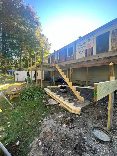 A wooden deck is being built on the side of a house