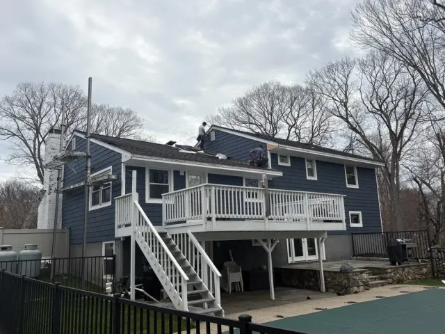Home with new navy vinyl siding and a white deck