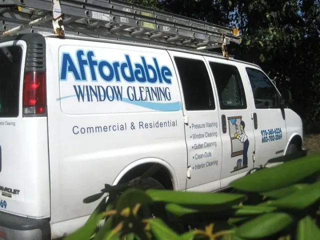 White van with "Affordable Window Cleaning" logo and services list, including pressure washing, window cleaning, and gutter cleaning. Ladder on the roof. Partial contact numbers visible.