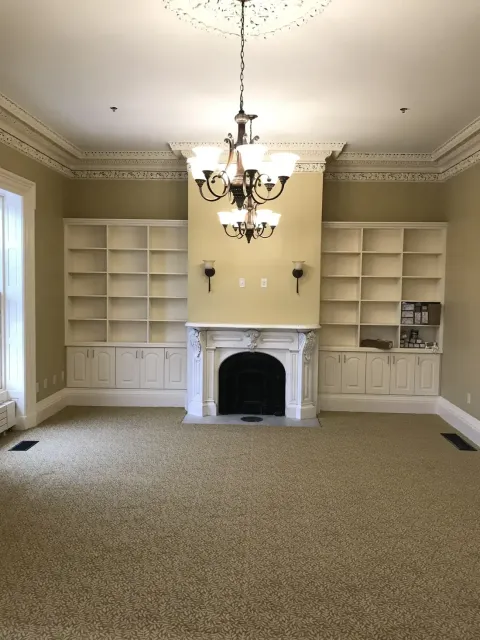 Historic room with painted built-in bookshelves and marble fireplace