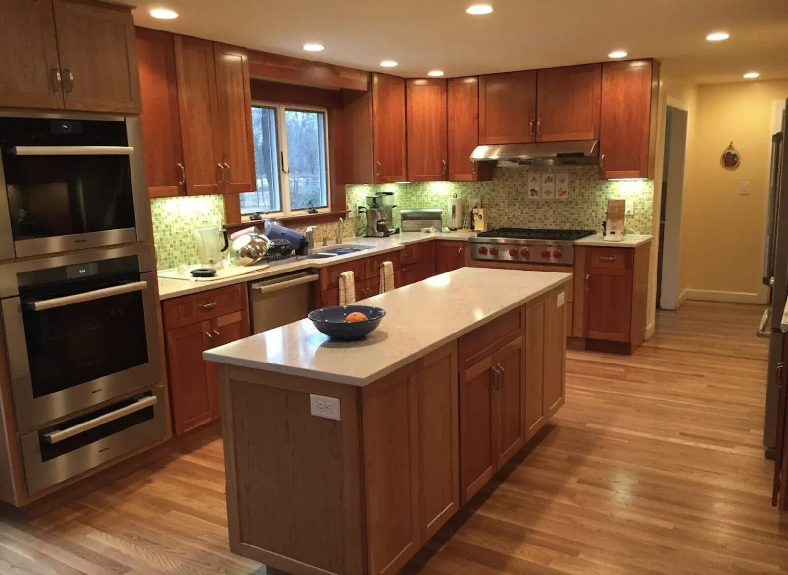 Warm-toned kitchen remodel in Acton, MA by Thomas Buckborough & Associates, featuring cherry wood cabinetry, quartz countertops, and a functional island