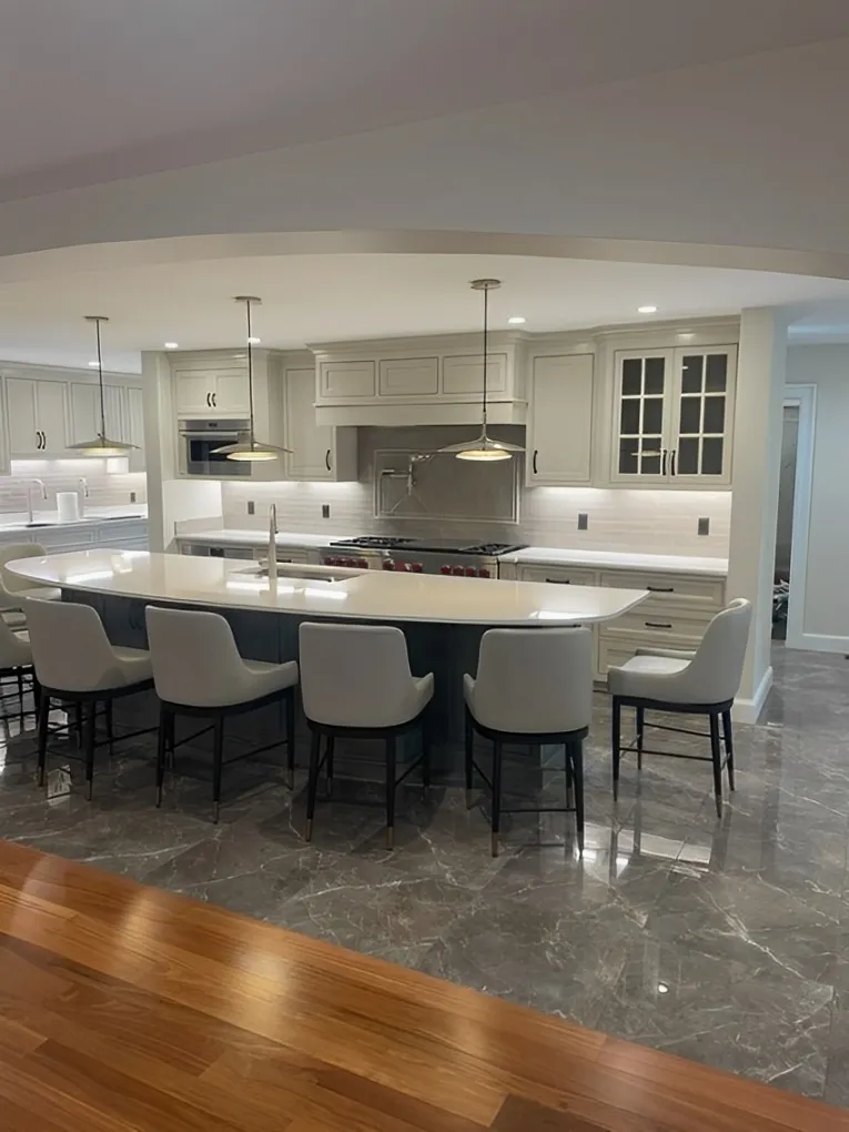 A Modern Kitchen Featuring A Central Island Surrounded By Stylish Chairs, Creating A Welcoming Dining Space.