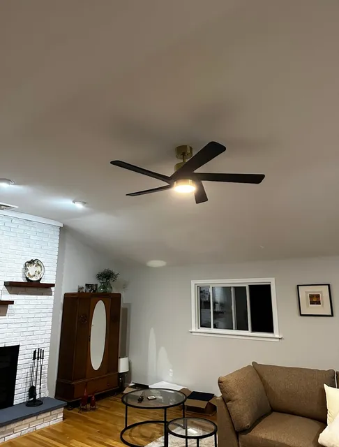 Living Room with a Ceiling Fan, Recessed Lighting, a White Brick Fireplace, and Brown Furniture