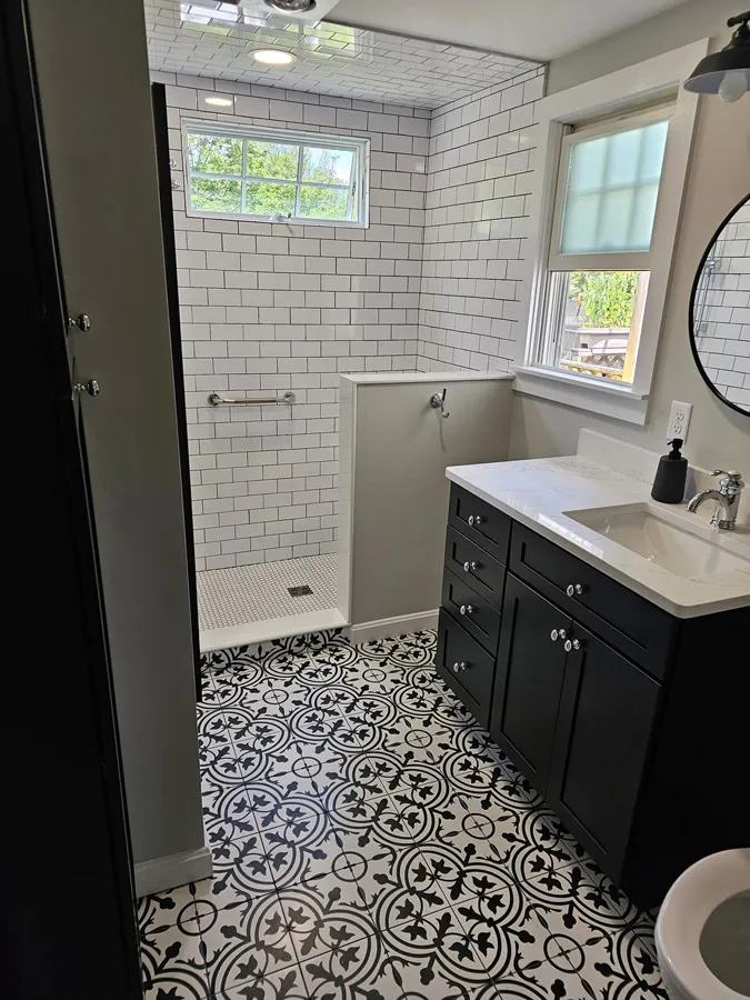 Remodeled bathroom with black and white patterned tile floor