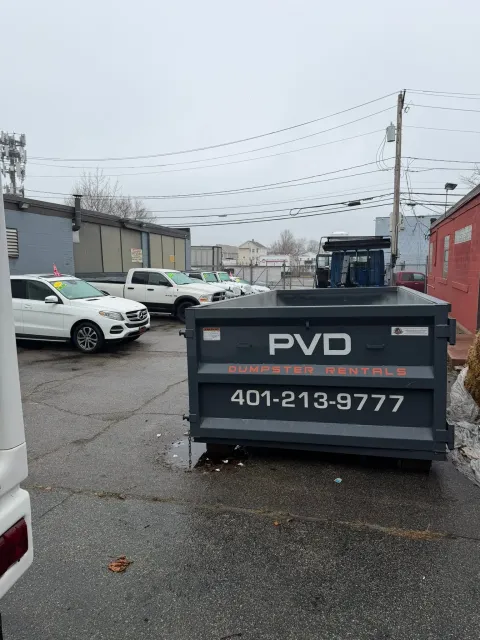 Roll-off dumpster in a commercial parking lot on a property management job in Rhode Island