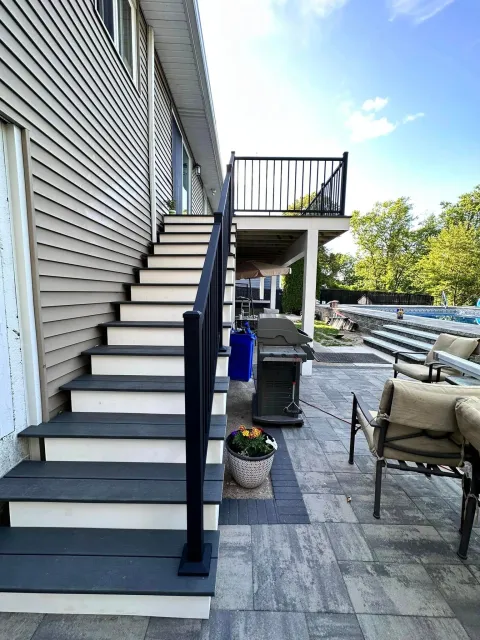 a set of stairs leading up to a patio with a grill .