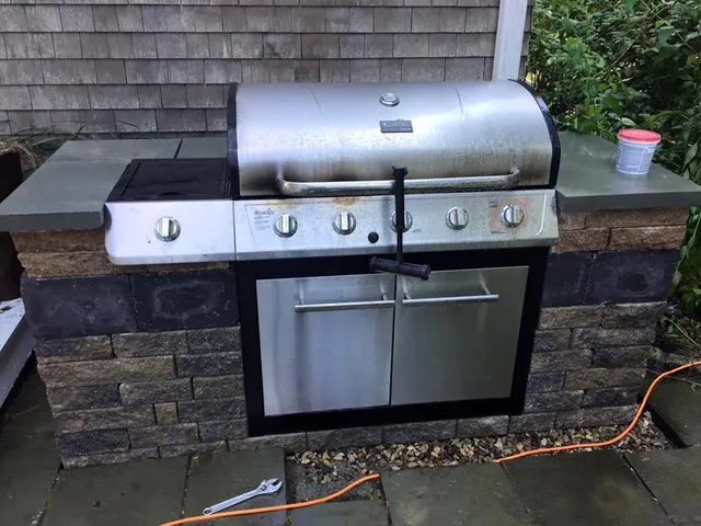 Built-in outdoor kitchen with stone surround