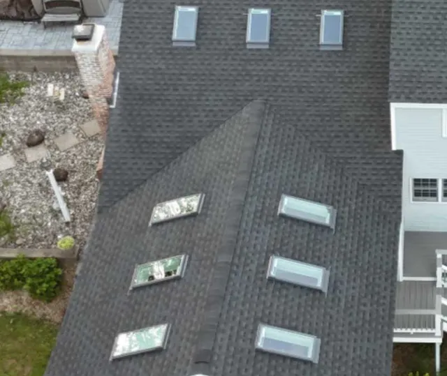 Aerial view of a shingle roof with two skylights installed