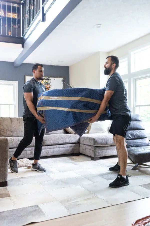 movers lifting heavy coffee table in a house