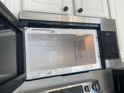 Stainless steel microwave above stovetop — move-out cleaning detail Raymond ME
