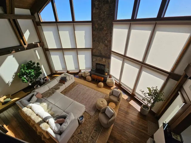 An aerial view of a living room with a couch , chairs , and a fireplace.