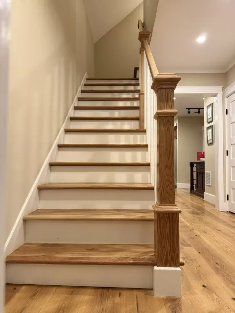 Finished staircase seen from the hallway, with the wood and paint finish visible from both rooms