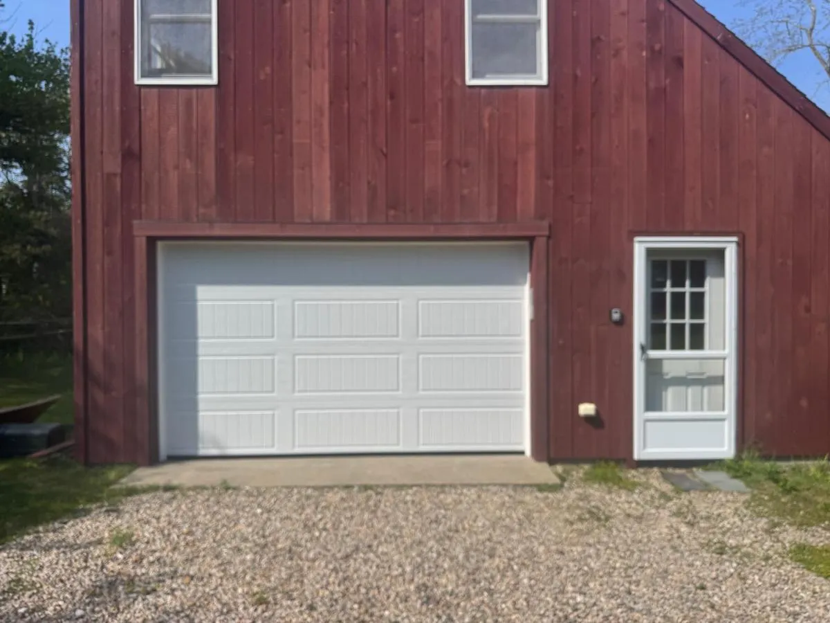 Bluefin white garage door on red barn-style building exterior