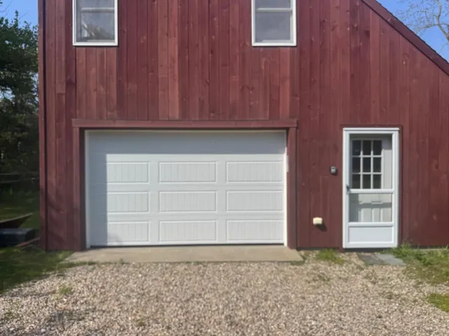 Bluefin white garage door on red barn-style building exterior