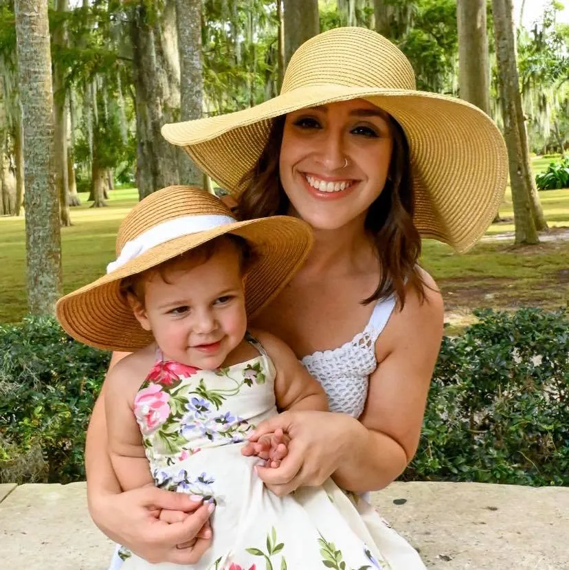 A woman wearing a hat and a baby wearing a hat.