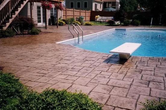 Brown stamped concrete pool deck with diving board