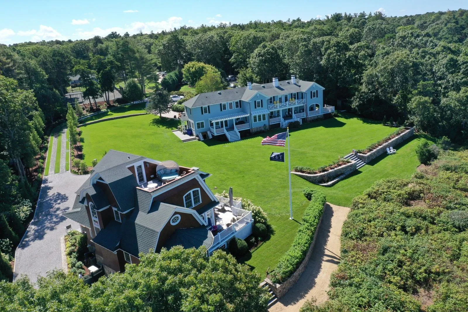 Aerial view of a sweeping Cape Cod waterfront estate showing landscape design, hardscape, and surrounding plantings