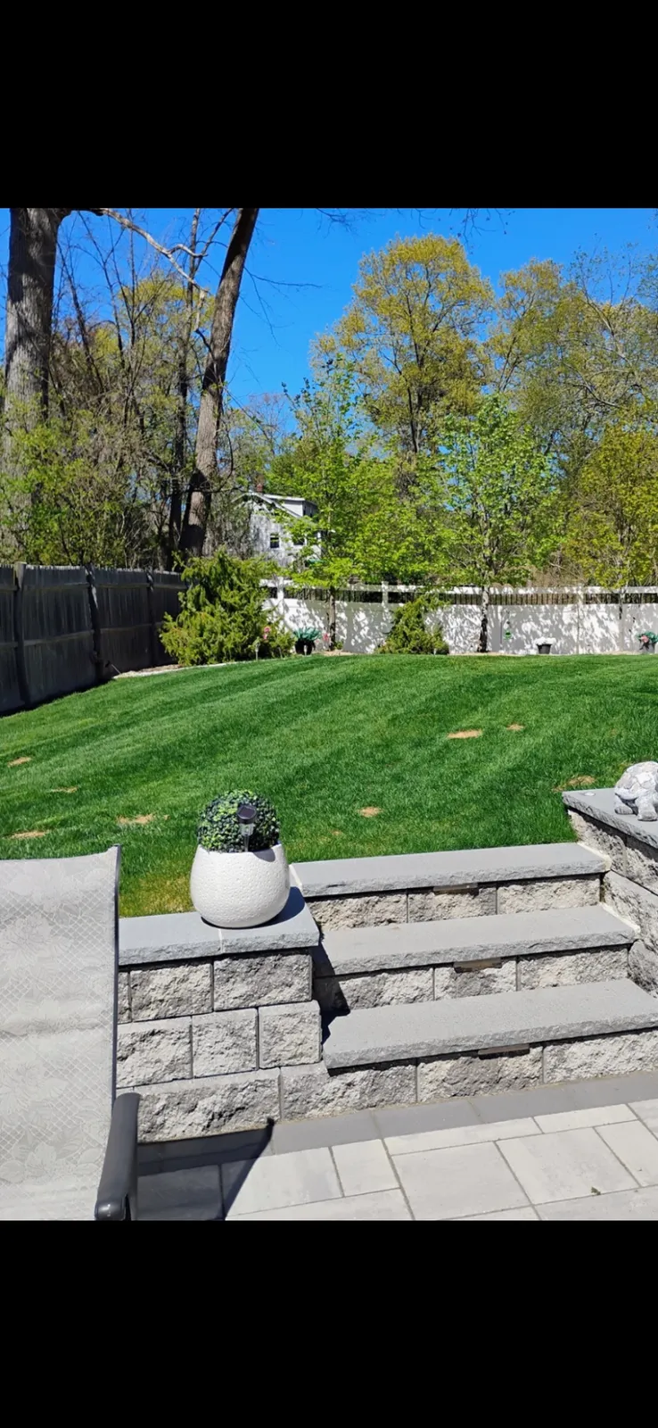 Backyard lawn with clean stonework and steps