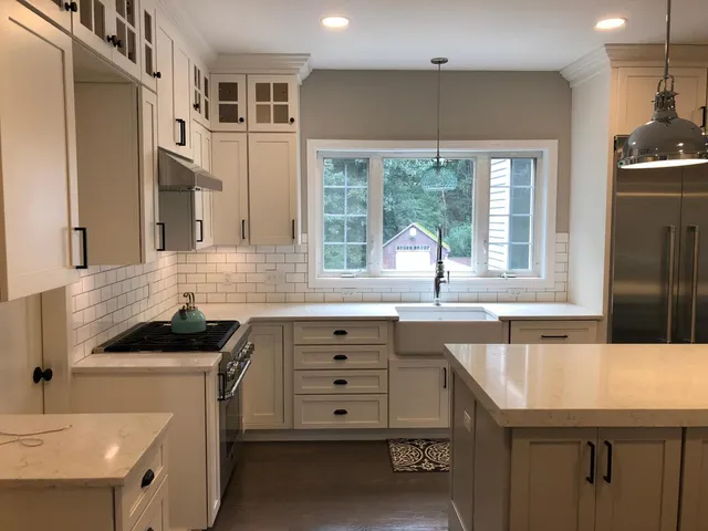 Interior of New Hampshire home remodeled kitchen with farmhouse sink, new appliances, new cabinets, and granite countertops