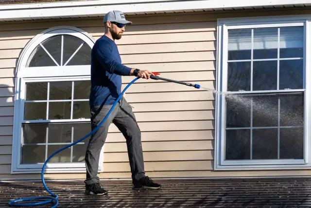 Man power washing a roof on a residential home