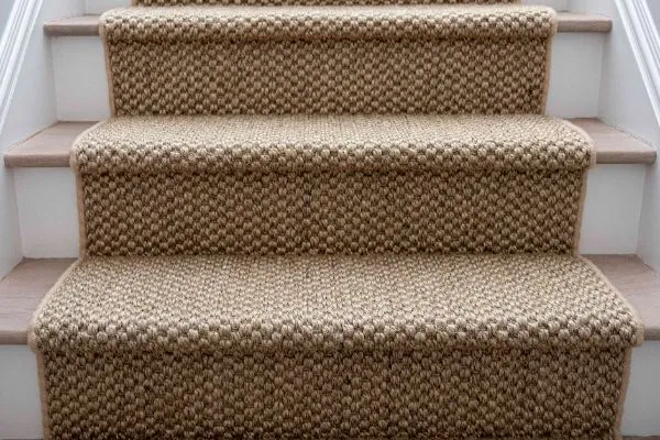 Close-up of a newly installed brown woven stair runner, showcasing the texture and pattern. Professional stair runner installation enhances home interior.