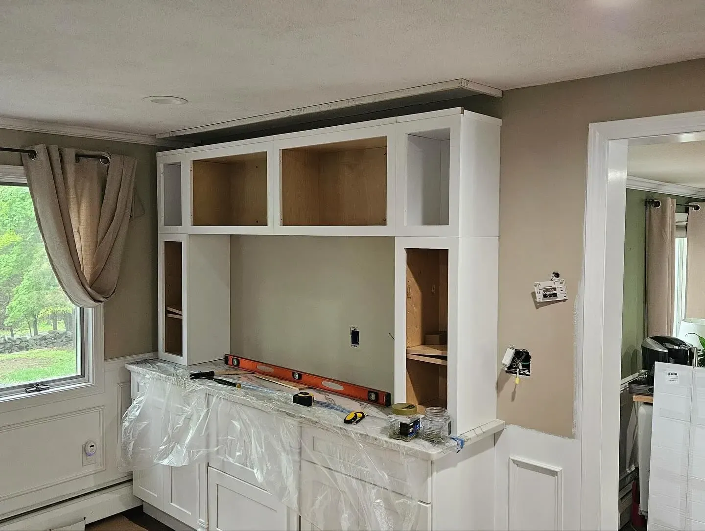 A living room with a built in entertainment center under construction.