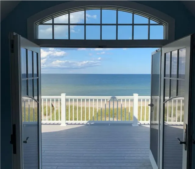 A double door style patio door looking out to a beach