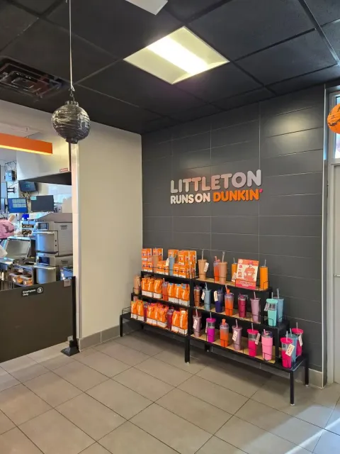 A littleton rainbow dunkin ' donuts store with a sign on the wall.