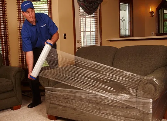 Man Shrink Wrapping Couch
