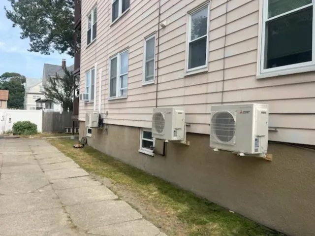 There are three air conditioners on the side of a building.