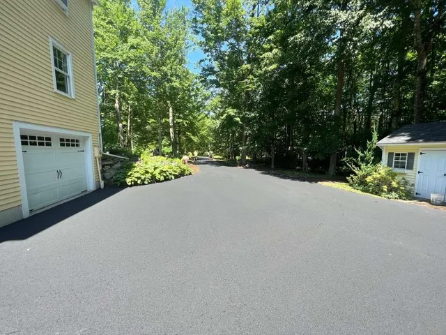 Residential driveway with trees and houses
