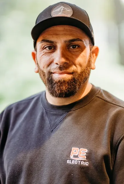 Man wearing a black cap and PE Electric sweatshirt.