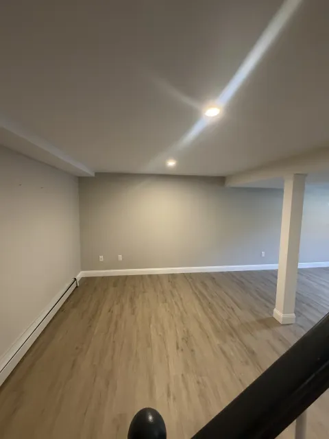 Newly finished open basement room with recessed lighting