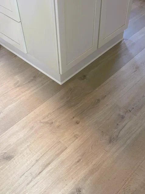 Light wood-look laminate or engineered wood flooring installation in a residential home by JK Flooring & Tile.