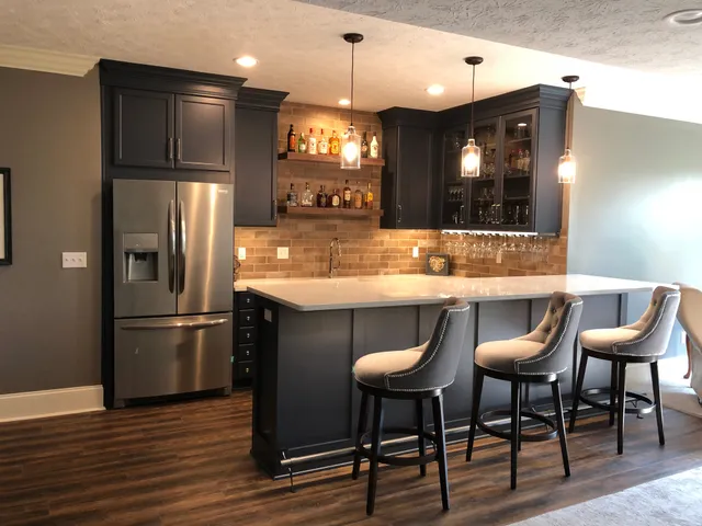 This is a basement bar for all family and holiday gatherings!

Haute Designs Kitchen & Bath. Bar. Designers Choice Cabinetry. Cabinet features: glass doors, wine glass hanging rack, double crown molding.