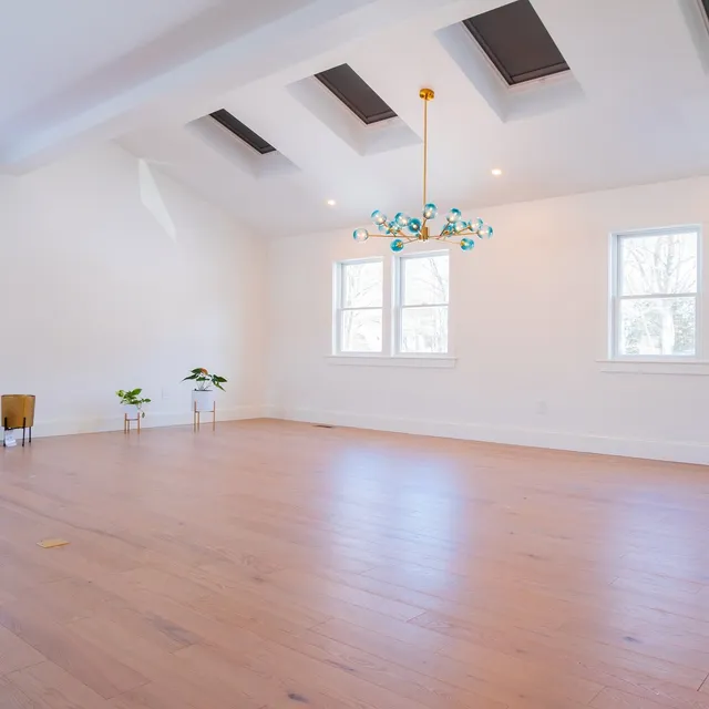 Bright vaulted room with skylights and new hardwood flooring