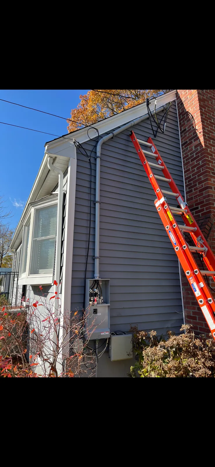 Ladder set at a home's exterior electrical service