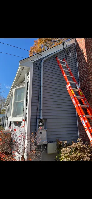 Ladder set at a home's exterior electrical service
