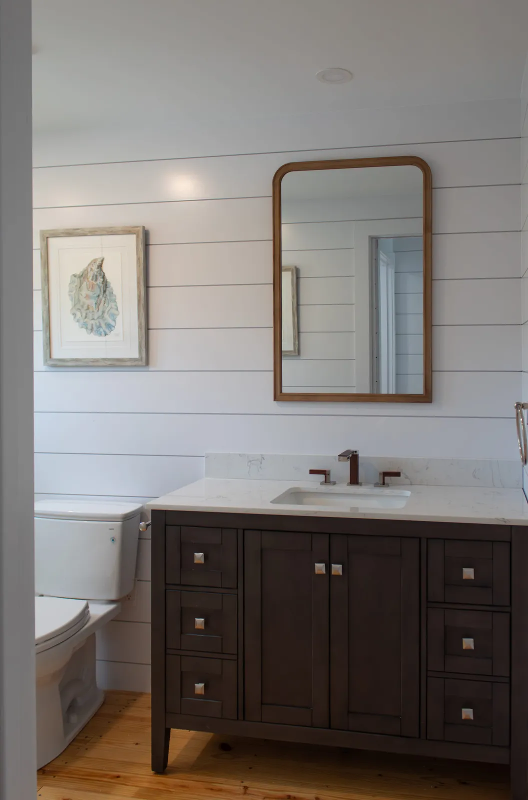 Bath with shiplap wall and dark vanity