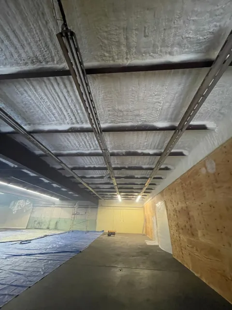 Shooting range interior, showing ceiling with metal supports, targets in the distance, and sound-dampening panels.