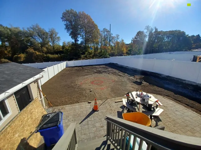 Before: Backyard dirt area with privacy fence