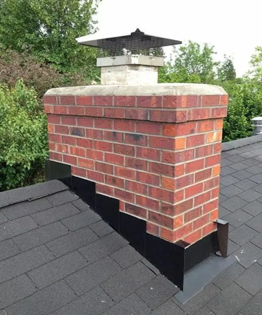 Brick chimney with a metal cap on a shingled roof